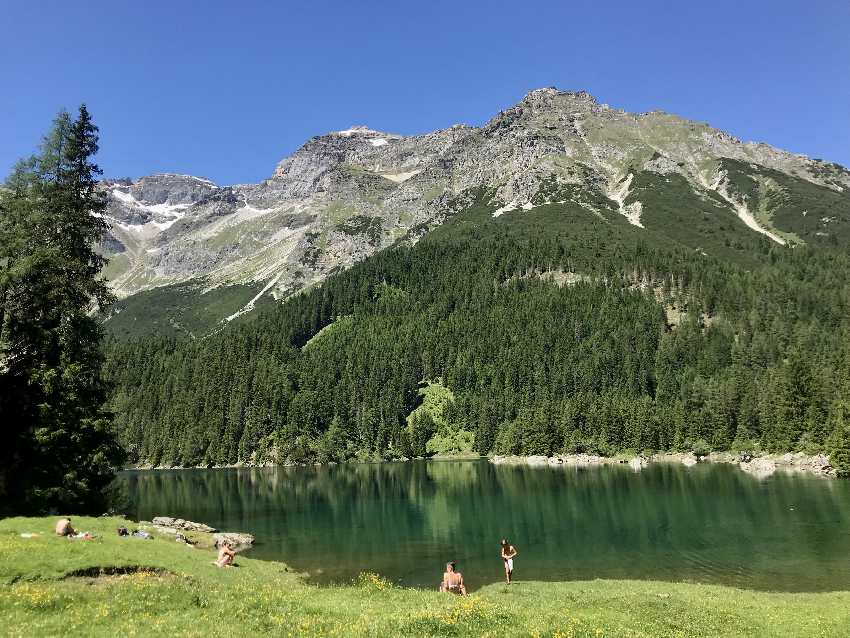 An diesem See in den Alpen baden und schwimmen